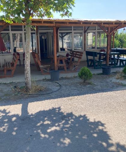 Kapalı kahvehanenin masasını kullanıp su içen aile, ayrılırken para ile not bıraktı